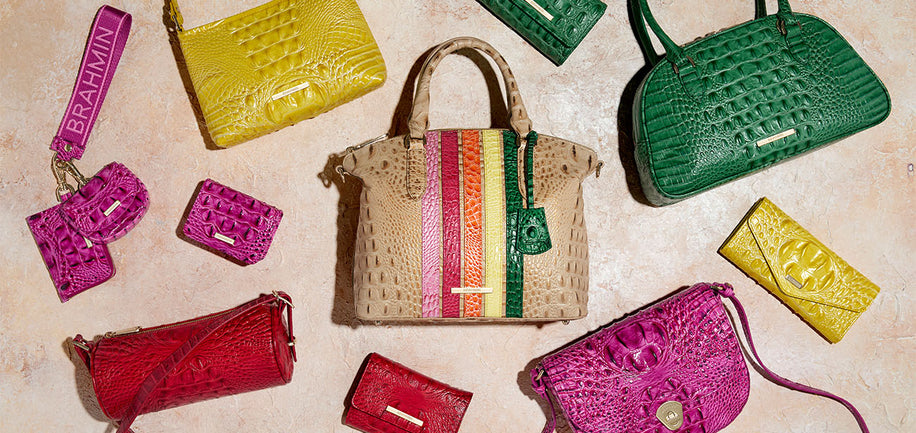Collection of colorful handbags and wallets on a textured surface
