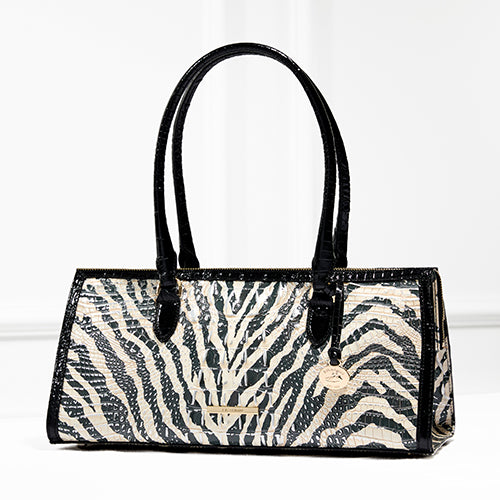 Brahmin Sophia satchel in bold black-and-white zebra embossed leather, designed with a structured rectangular silhouette, double top handles, and signature hanging medallion charm.