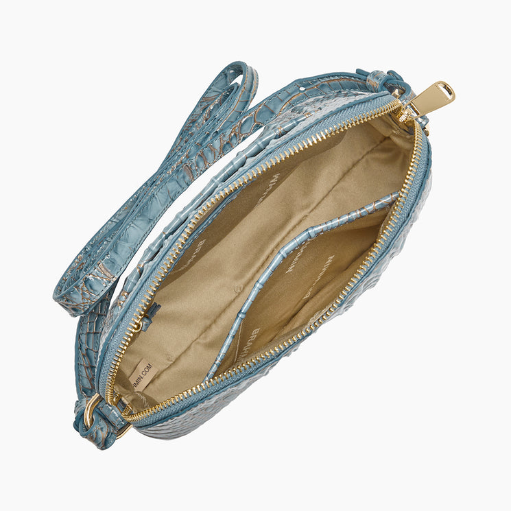 A light blue crocodile-embossed leather crossbody bag shown open from a top-down view, revealing a beige interior lining with gold-tone hardware.