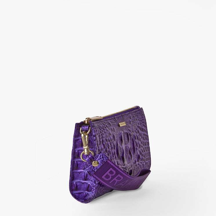 Brahmin purple embossed handbag with a gold zipper, shiny gold hardware, and a wide purple strap labeled BRAND. Structured silhouette shown upright on a white background.