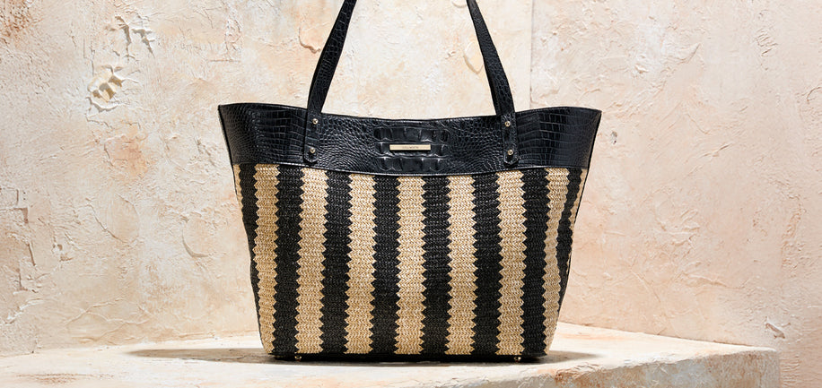 Black and beige Brahmin striped tote bag on a stone surface