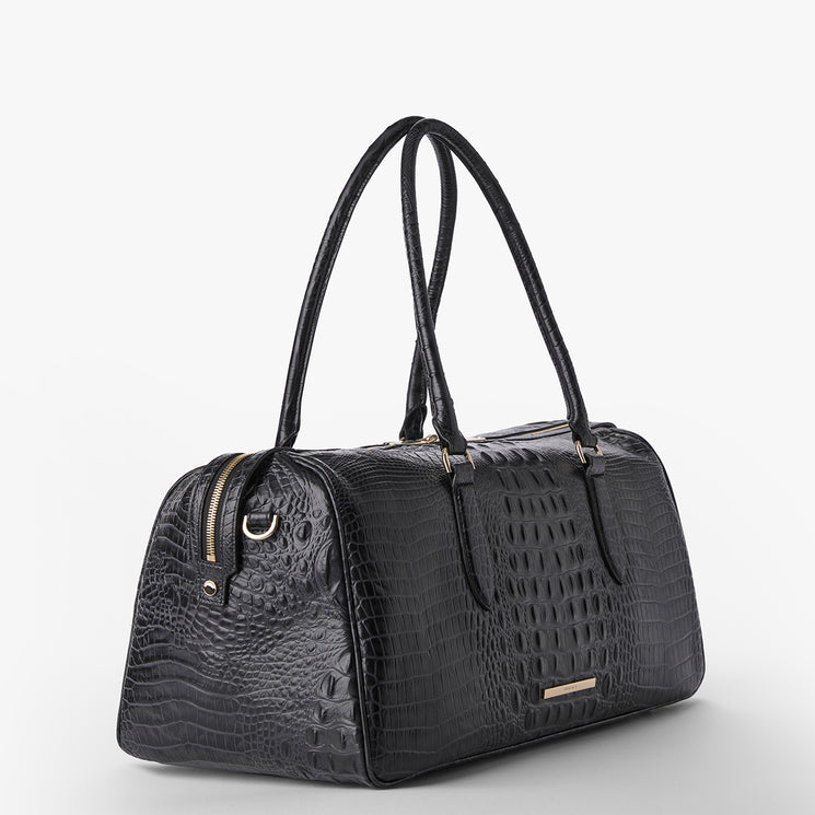 Brahmin black embossed leather handbag with a structured silhouette, long double handles, gold-tone hardware, and a zippered top, shown on a white background. Features rich texture and elegant design.