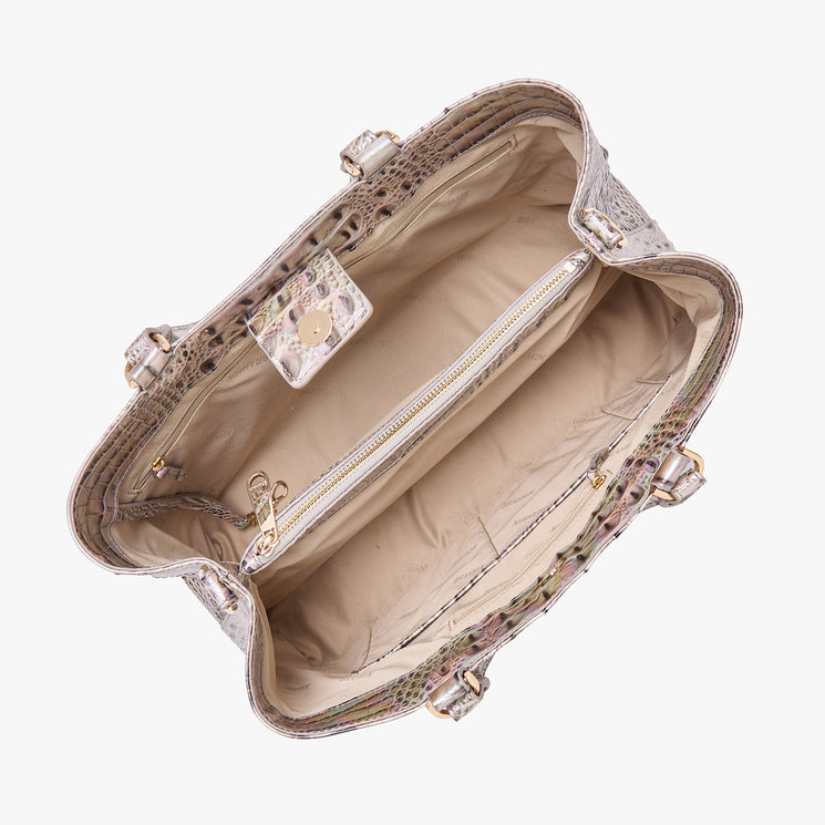 Top view of an open Brahmin beige satchel with textured exterior, gold hardware, spacious interior with a zippered pocket and two open pockets; structured design highlights organization features.