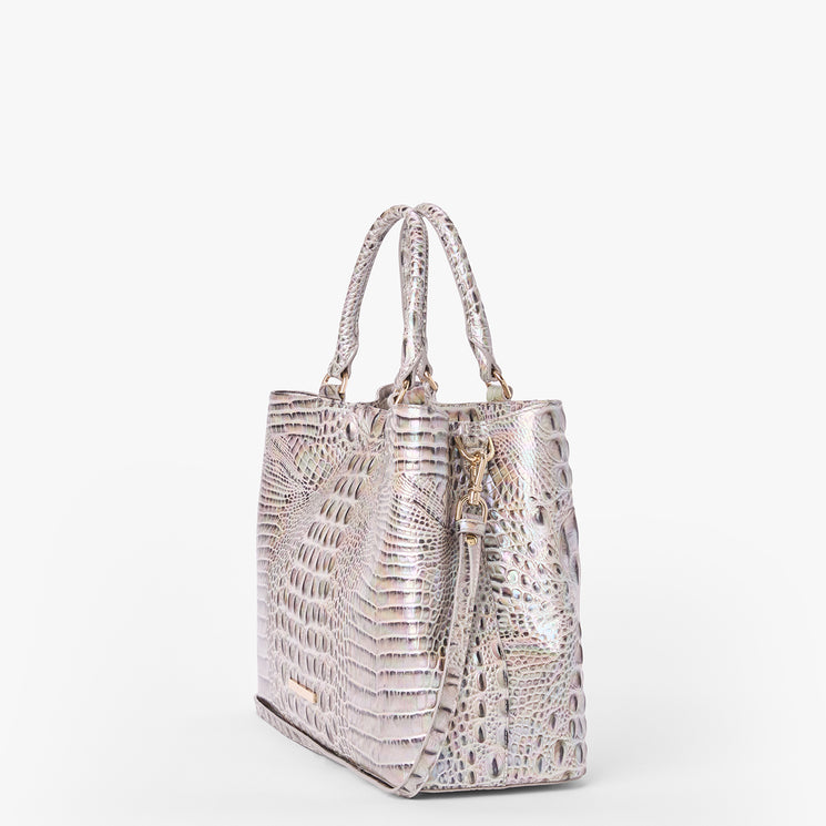 Brahmin metallic embossed handbag with two top handles, detachable shoulder strap, structured silhouette, glossy finish, textured pattern, gold-tone hardware; shown at an angle on a white background.