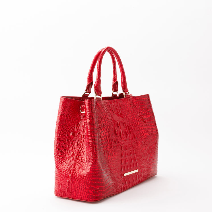 Bright red Denise tote by Brahmin featuring a structured silhouette, dual handles, and a glossy, textured embossed pattern with gold-tone hardware.
