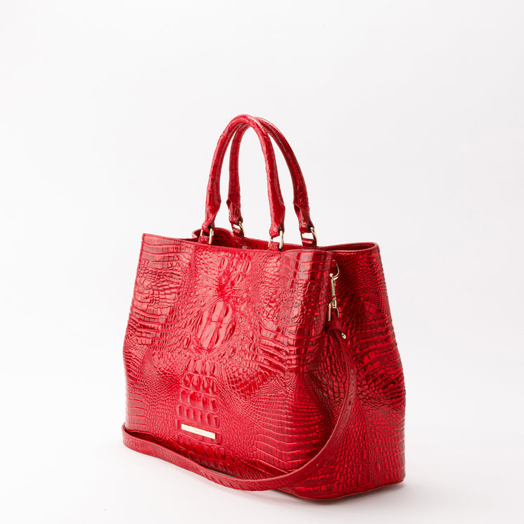 Holiday red Brahmin Denise carryall featuring a croc-embossed texture, double top handles, detachable shoulder strap, gold-tone hardware, and a rectangular front metal plate.