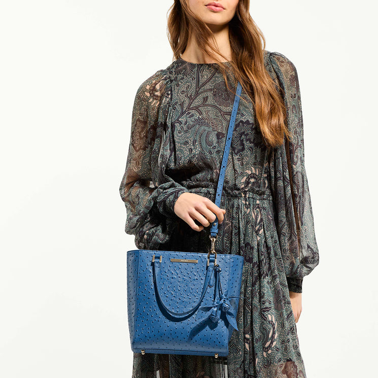 Woman wearing Harrison Satchel as a crossbody against a white background