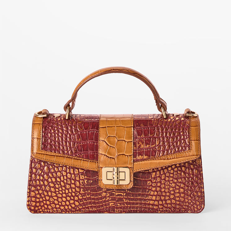 A structured handbag with a top handle, featuring a dual-texture design with a reddish-brown crocodile-embossed pattern and a smooth tan leather center panel and trim, finished with a gold-tone turn-lock clasp on a light gray background.