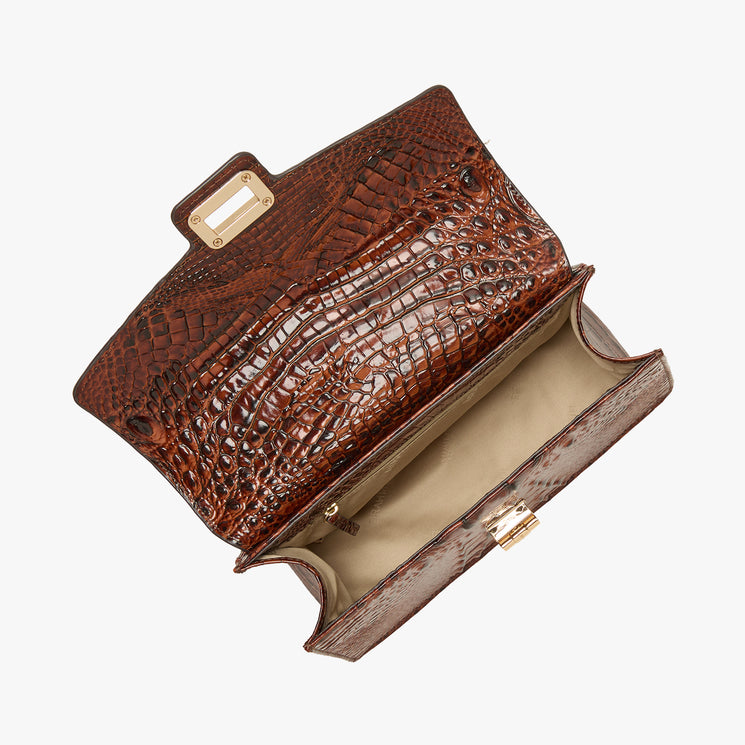 A brown crocodile-embossed leather clutch bag shown open, displaying its interior lining and gold-tone hardware, set against a plain white background. Open top view.