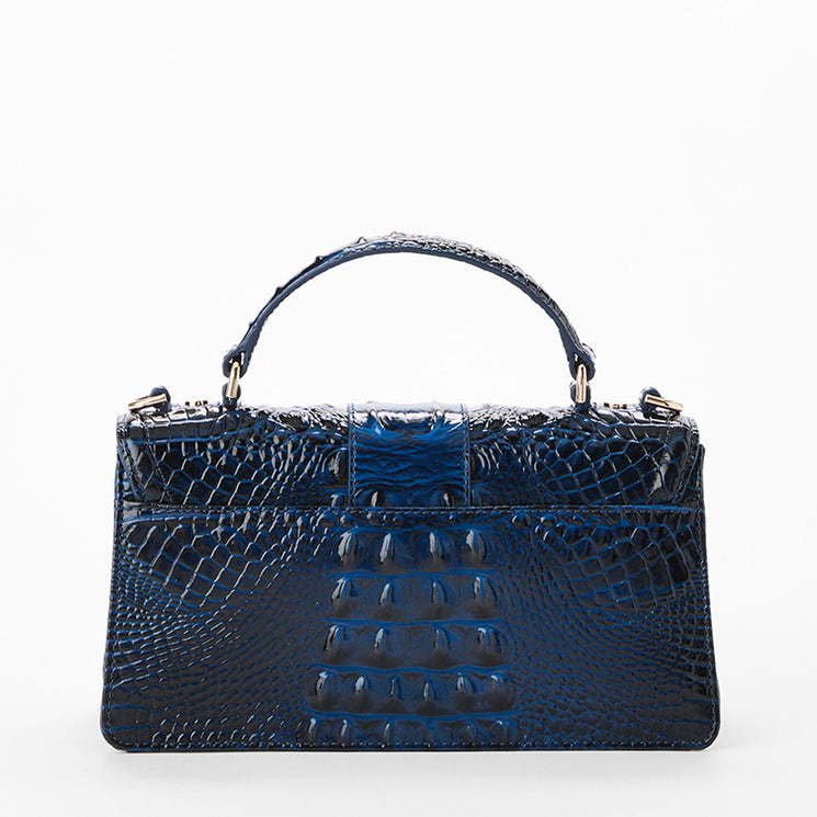 A dark blue crocodile-embossed leather handbag with a top handle, shown against a plain white background. Back view.