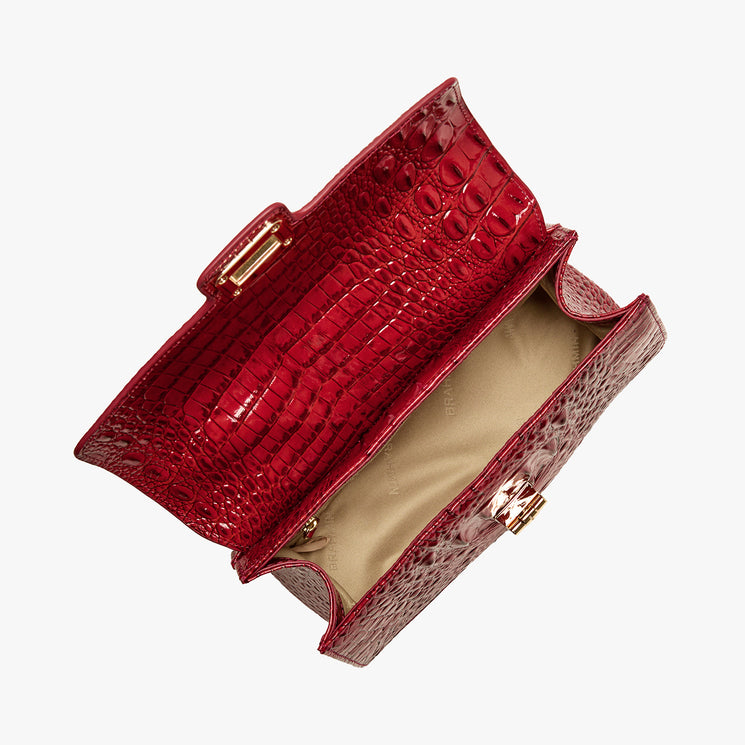 Red crocodile-patterned handbag on a white background. Open top view.