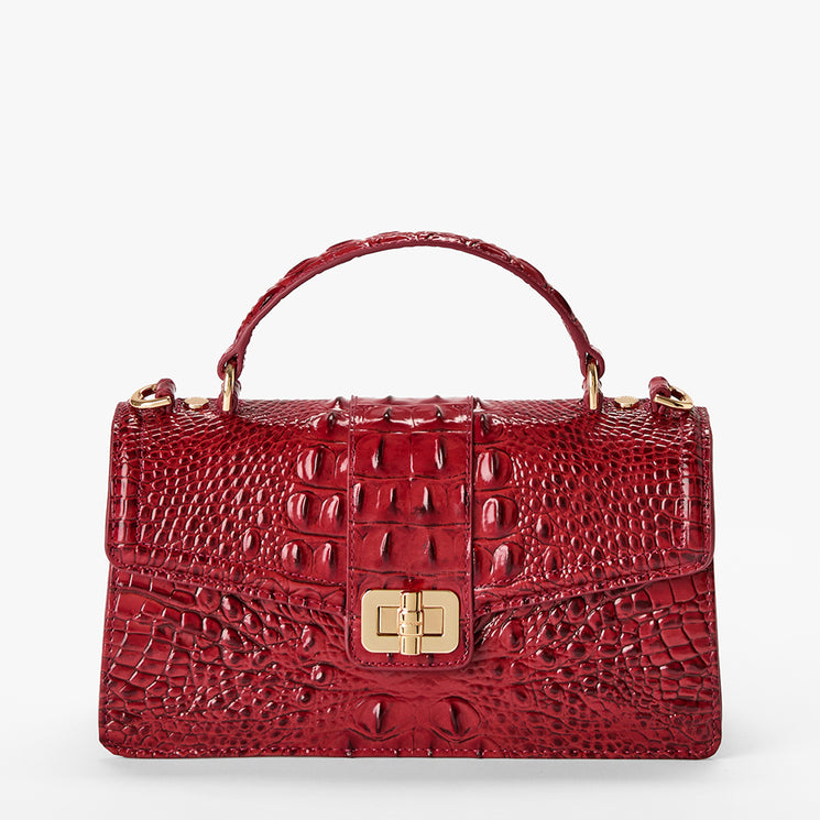 Red textured handbag with gold accents on a white background. Front view.