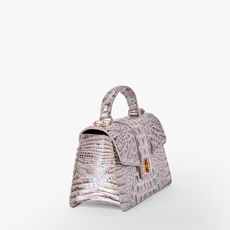 Brahmin iridescent handbag with embossed texture, structured silhouette, top handle, gold-tone clasp hardware, and side-front angled view against a white background. No strap or interior details visible.