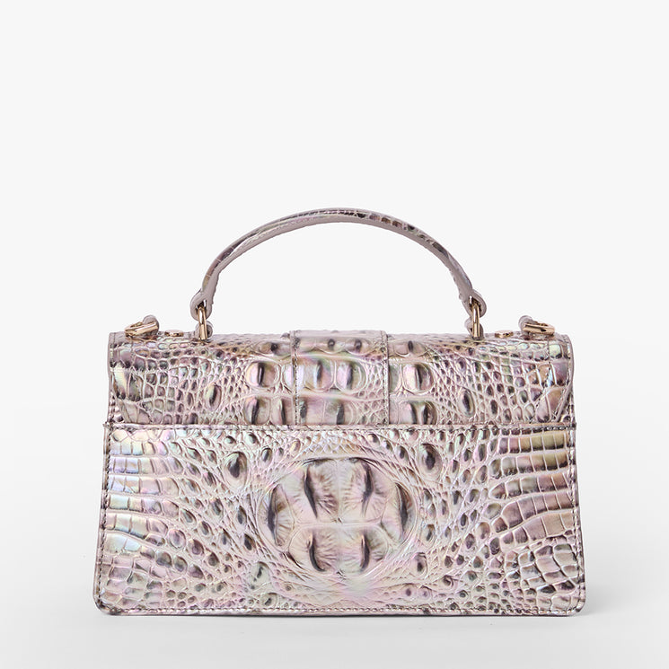 Brahmin iridescent embossed handbag with structured rectangular silhouette, top handle, and gold-tone hardware, shown against a white background. Bag features textured pattern and sleek design for hand carry.