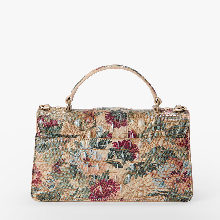 A structured handbag with a top handle, featuring a textured crocodile-embossed pattern overlaid with a vintage floral tapestry print in beige, burgundy, green, and blue.