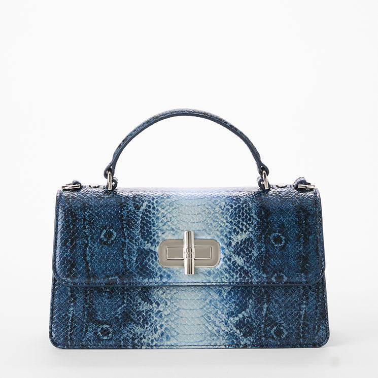 A blue snakeskin-patterned handbag with a top handle and silver-tone hardware, photographed against a clean white background. Front view.