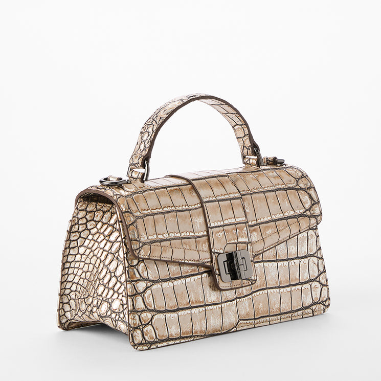Beige crocodile-patterned handbag on a white background. Side view.