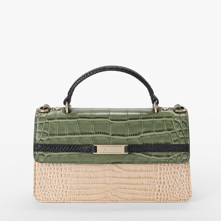 A structured handbag with a top handle, featuring a green crocodile-embossed flap and a beige crocodile-embossed body, separated by a black textured band with a central gold-tone Brahmin plate.