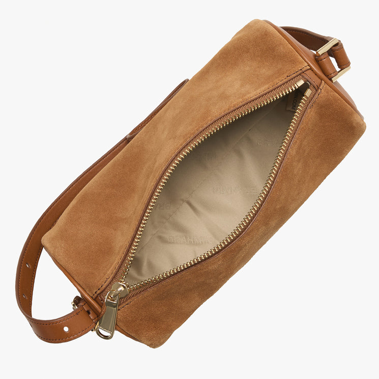 A tan suede or faux-suede cylindrical pouch bag with an open gold-tone zipper, showing a light beige interior lining, on a plain white background.