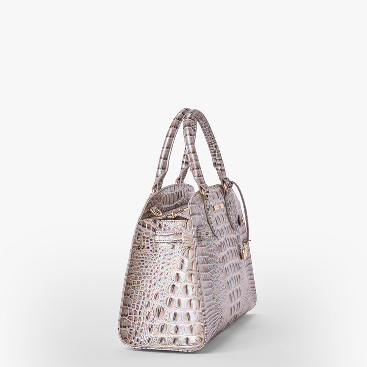 Brahmin pinkish-beige embossed satchel with double handles, gold-tone hardware, structured silhouette, and textured pattern, shown on a plain white background. No visible strap or interior details.