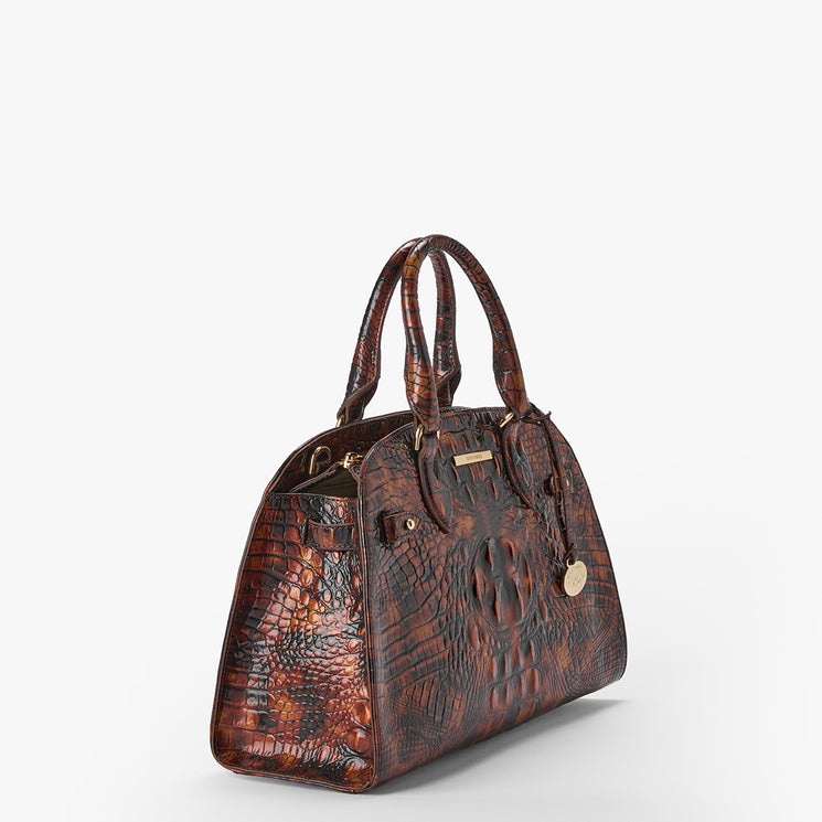 A brown textured handbag with a crocodile skin pattern, featuring dual top handles, a front flap pocket with a hanging keychain, and gold-tone hardware, photographed on a light gray background.
