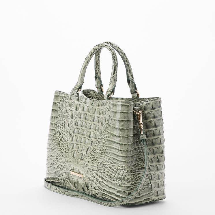 A sage green crocodile-embossed leather handbag with dual top handles and a matching shoulder strap, shown on a clean white background.