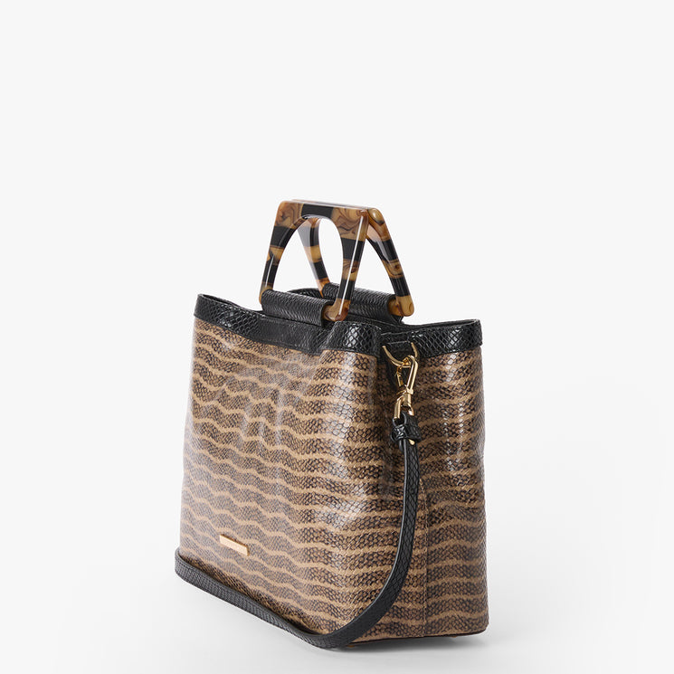 Small Denise handbag with wavy pattern and tortoiseshell handle on a white background. Side view with strap.