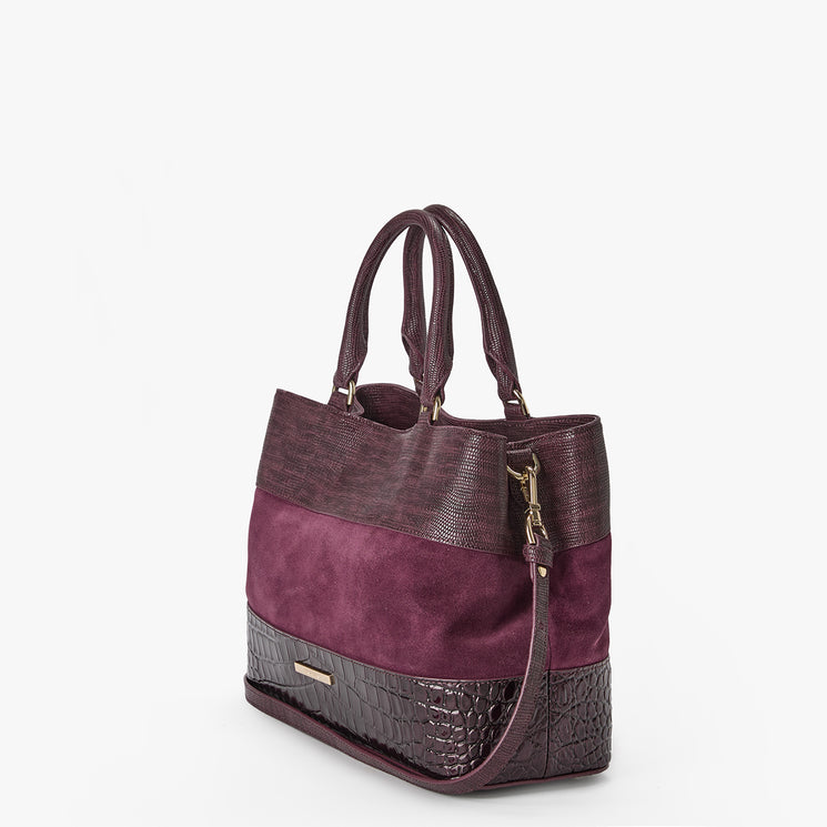 A structured tote bag in a color-blocked deep plum purple, featuring a textured faux-crocodile leather lower section, a smooth suede-like middle band, and a darker textured faux-leather top section with dual top handles and an attached strap.