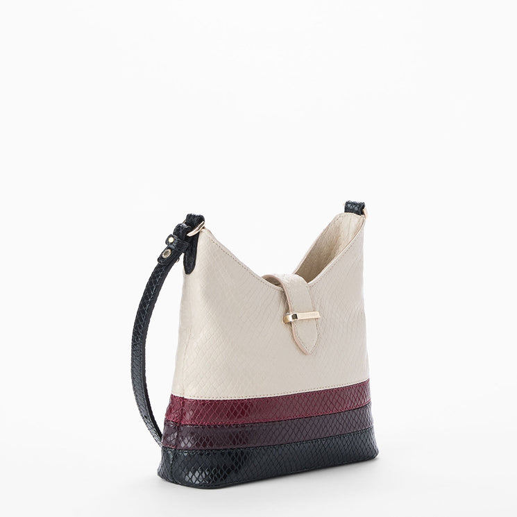 Cream Small Gwynne crossbody bag with black and red accents on a white background. Side view.