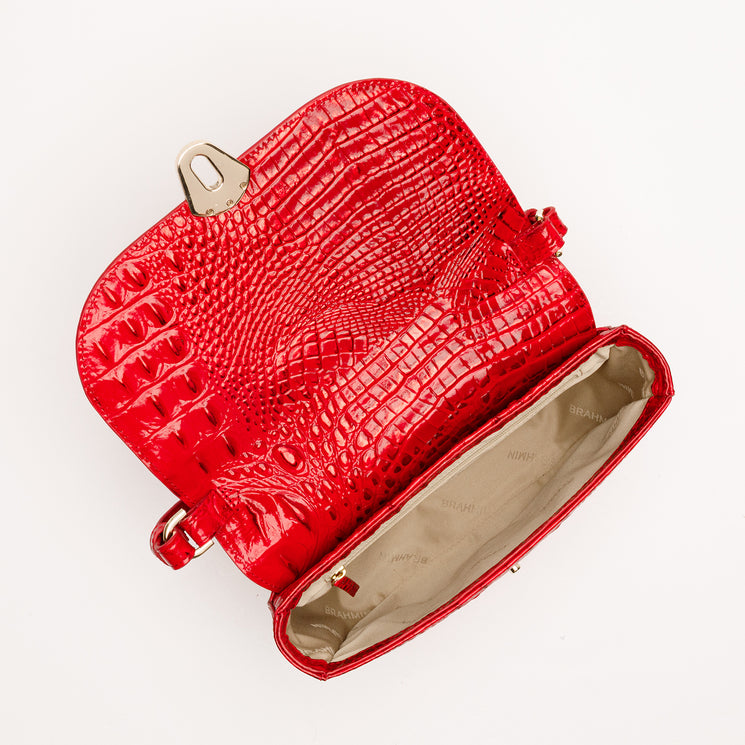 Brahmin Portia handbag in red with a glossy, embossed animal-inspired pattern, featuring gold-tone turn-lock hardware and an open, fabric-lined interior.