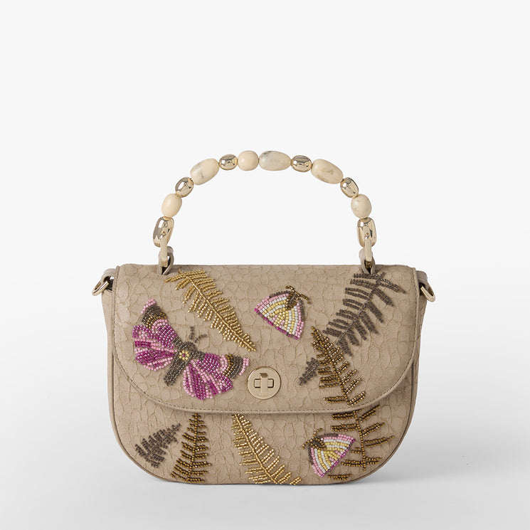 Beige handbag with butterfly and fern designs on a white background. Portia front view.