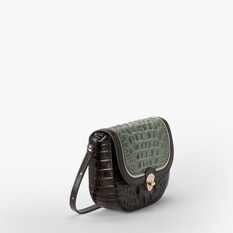 A structured shoulder bag with a dark brown crocodile-embossed body and a contrasting sage green crocodile-embossed flap, featuring a gold-tone turn-lock closure and a thin dark strap, set against a plain light gray background.
