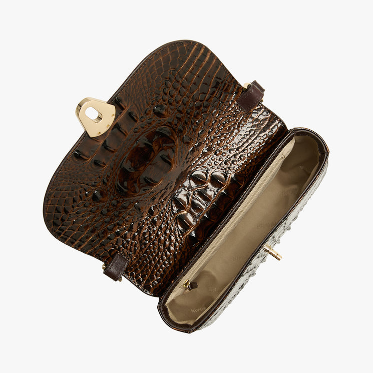 A dark brown crocodile-embossed leather clutch bag, shown open to display its interior lining and gold-tone hardware, set against a plain light gray background.