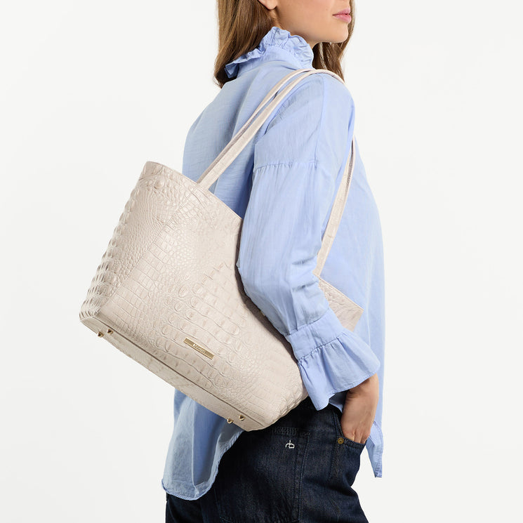 Woman carrying Mona tote bag with a white background