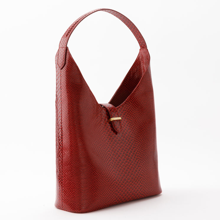 Brahmin Gwynne shoulder bag in red with an embossed textured finish, featuring an arched top handle and a center gold-tone hardware clasp.
