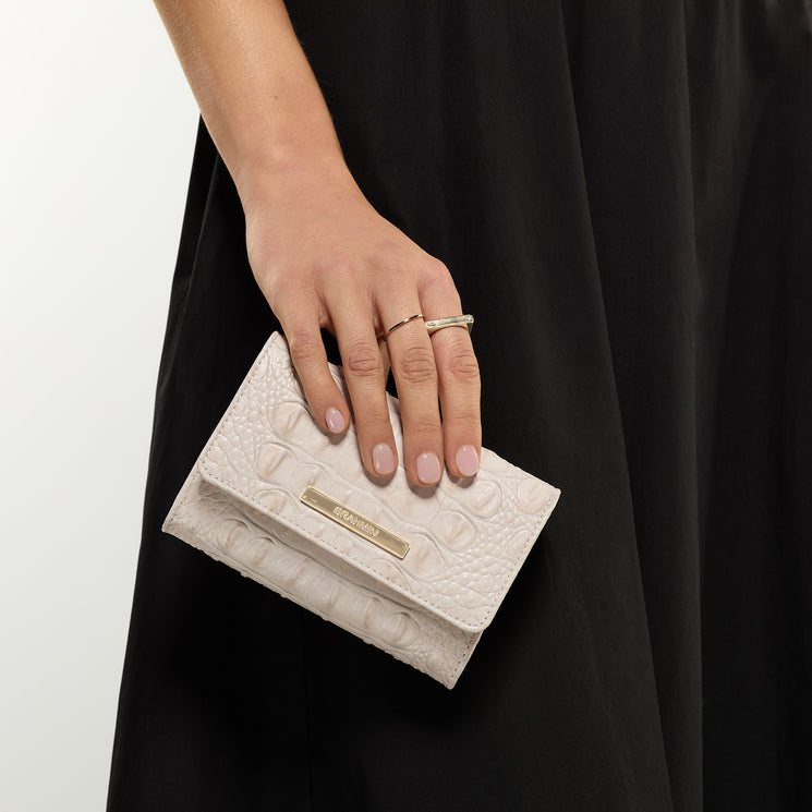 Hand holding Kerra clutch against a black background