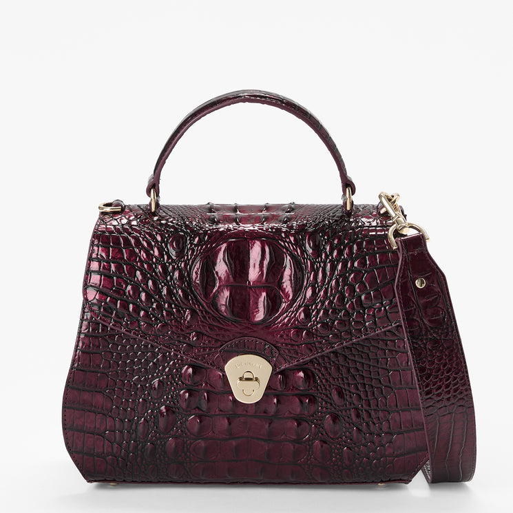 A structured top-handle handbag with a glossy embossed crocodile pattern in deep burgundy and a gold-tone turn-lock closure, shown on a clean white background.