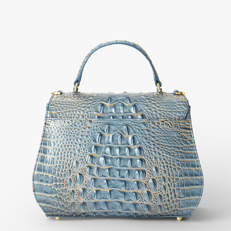 A structured blue crocodile-embossed handbag with a top handle and gold-tone hardware, photographed against a clean white background.