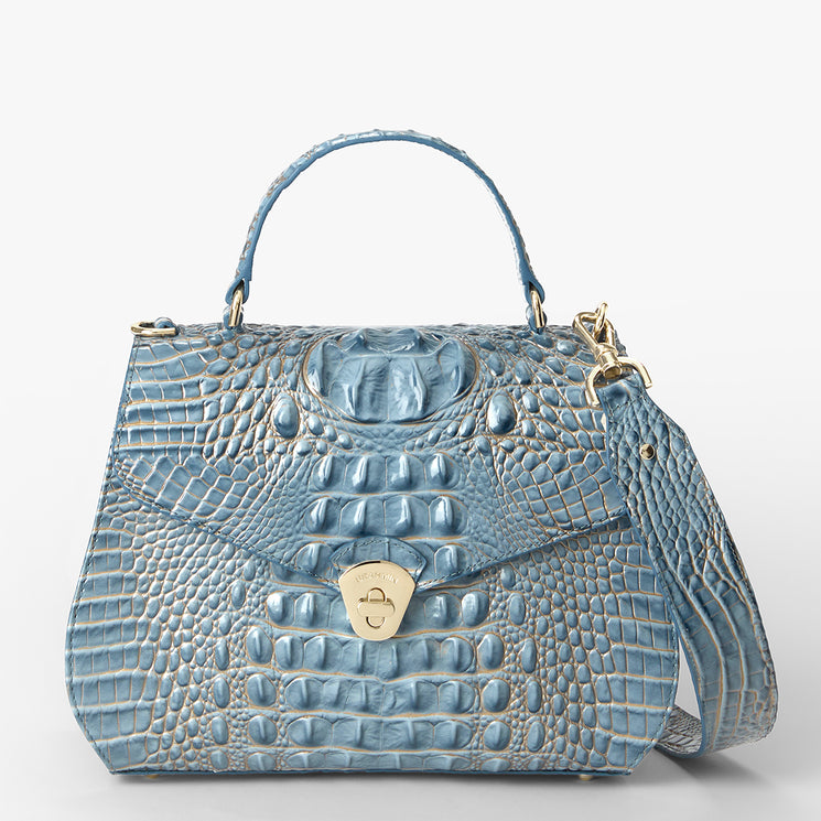 A light blue crocodile-embossed leather handbag with a top handle, gold-tone hardware, and a detachable shoulder strap, shown against a plain white background.