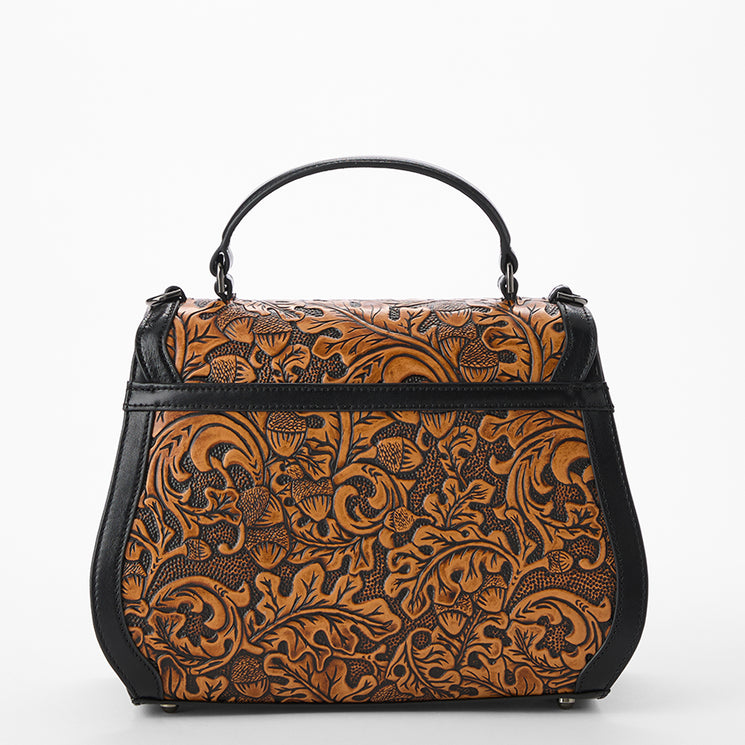 Brown leather handbag with intricate patterns on a white background. Annalise back view.