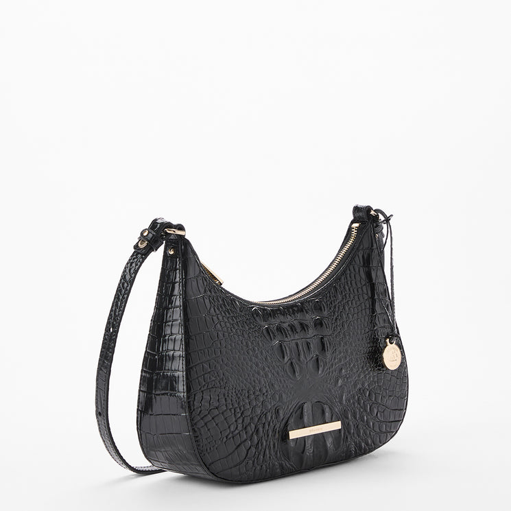 Black crocodile-embossed leather shoulder bag with gold-tone hardware, a top zipper, and a hanging round charm, shown on a clean white background. Side view.