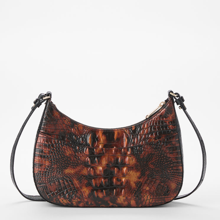 A crescent-shaped shoulder bag with a glossy brown and black crocodile skin embossed pattern, featuring a black strap and gold-tone hardware, set against a plain white background.