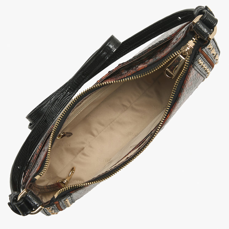 An open handbag shown from above on a light gray background, featuring a black textured shoulder strap, a patterned exterior in brown and beige tones, and a beige interior lining with gold-tone zippers.
