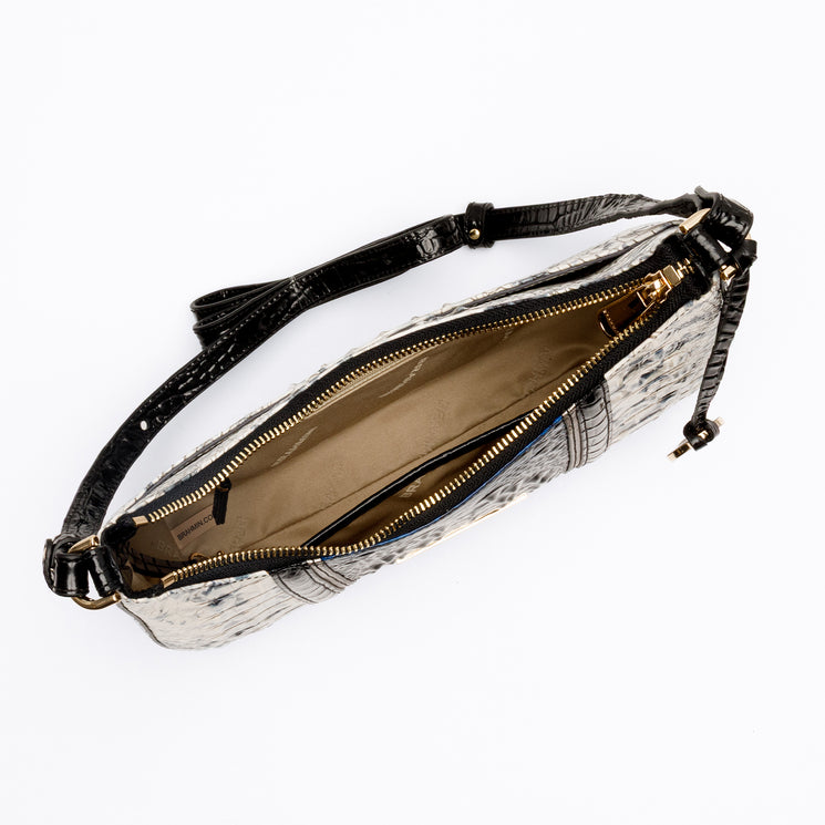 Top-down view of a BRAHMIN Small Stephie shoulder bag in a black-and-white textured animal pattern. Features a crescent-shaped silhouette, gold-tone hardware, zipper closure, and an adjustable shoulder strap.