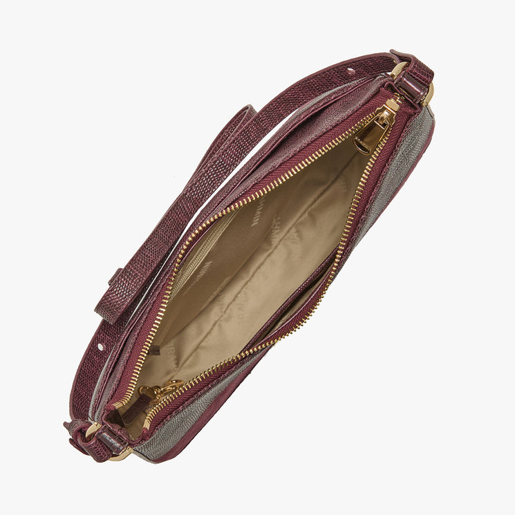 A top-down view of a burgundy textured leather handbag with a beige interior and gold-tone zippers, shown on a light gray background.