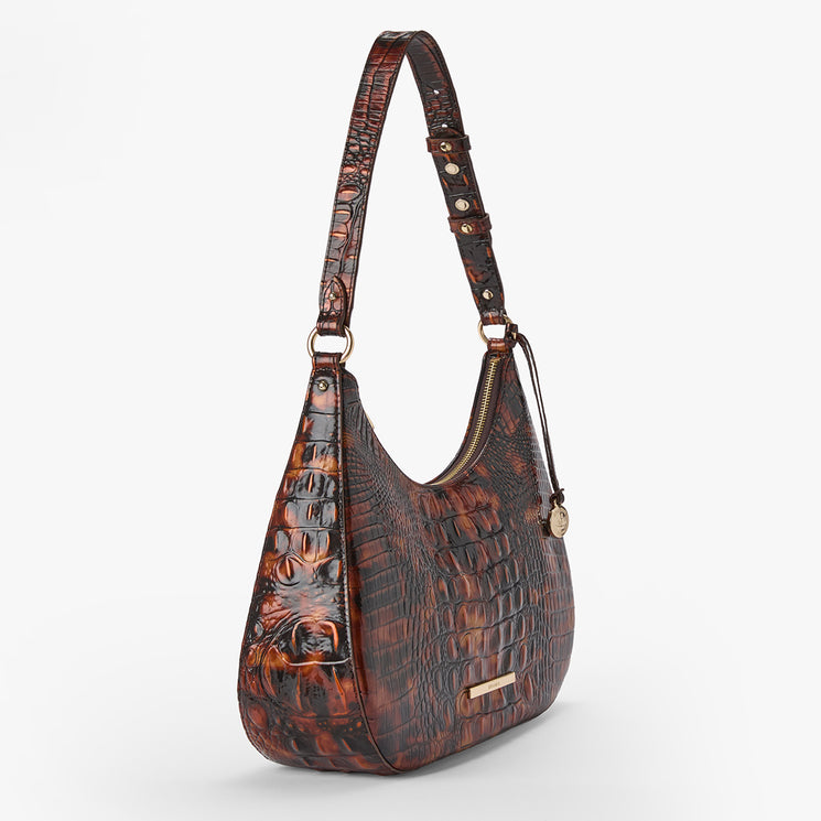Brahmin brown shoulder bag with embossed textured pattern, curved silhouette, gold-tone hardware, small pendant charm, short adjustable strap; shown on white background with exterior details visible.