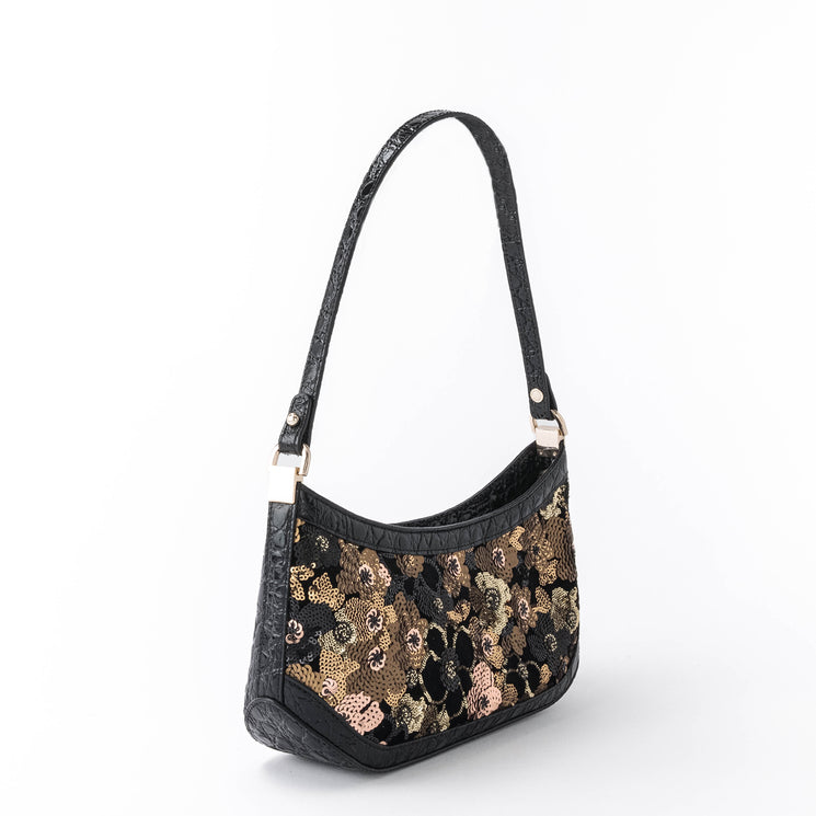 BRAHMIN Lilibeth black velvet handbag with gold, bronze, and pink sequin floral pattern, single top strap, gold-tone hardware; shown against a white background. Sophisticated evening bag silhouette.