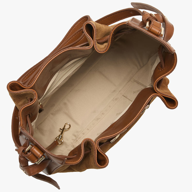 A brown leather shoulder bag with a ruffled, bucket-like silhouette, shown from an overhead angle. The bag features a warm tan interior lining and gold-tone metal hardware, including a hook-and-loop closure and a strap buckle.