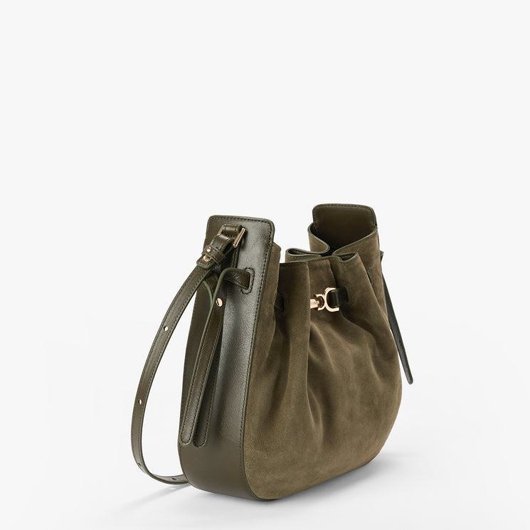 An olive green drawstring shoulder bag with a smooth leather strap and a gold-tone detail, shown on a clean white background.
