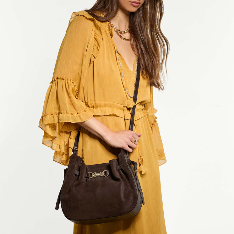 Woman wearing Marge crossbody wearing a yellow dress on a white background